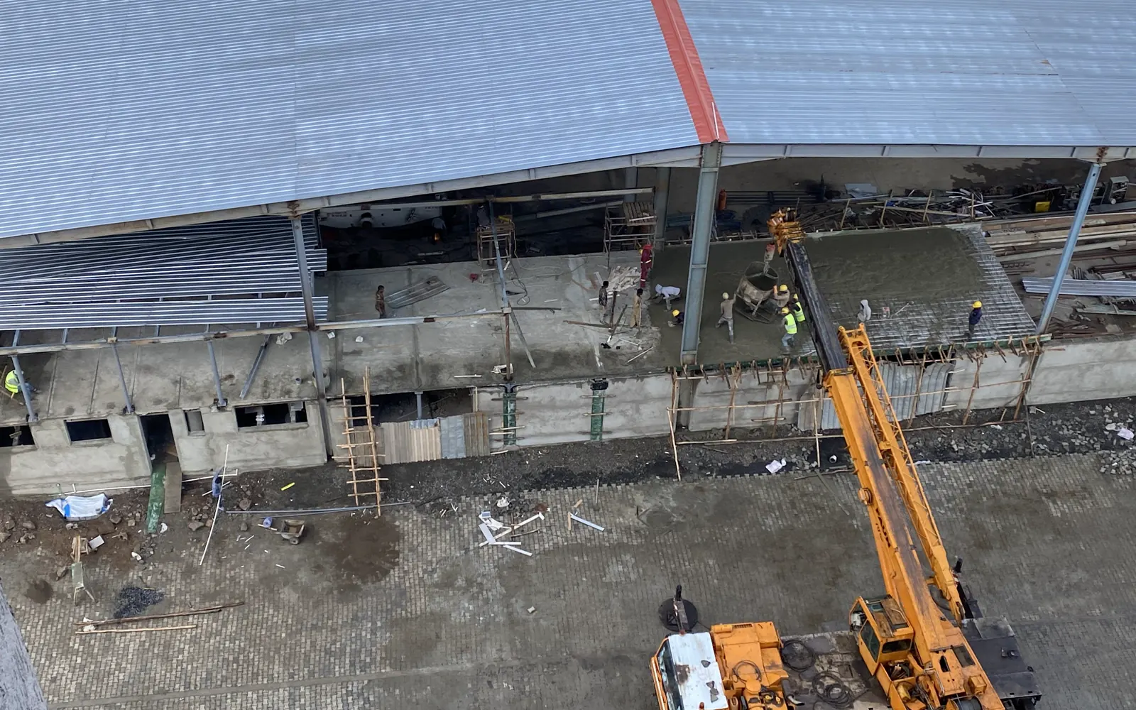 Concrete placement underway with a mobile crane and site team