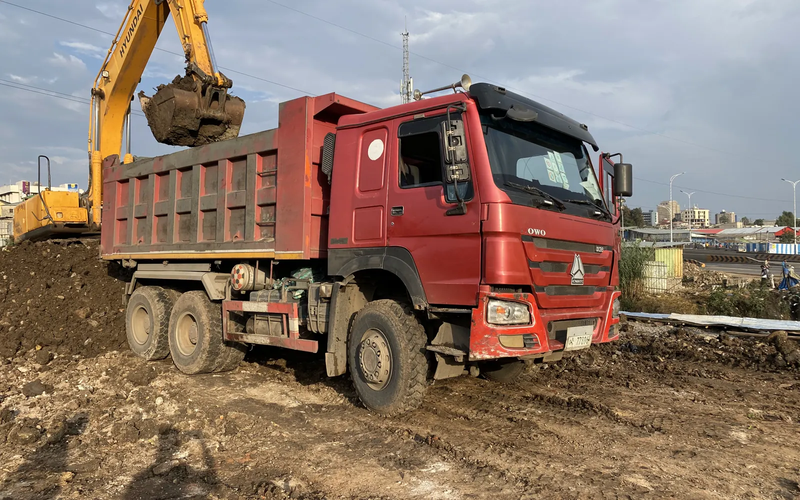 Excavator loading a dump truck during active earthmoving work